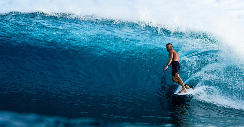 Person surfing on a large wave in the ocean