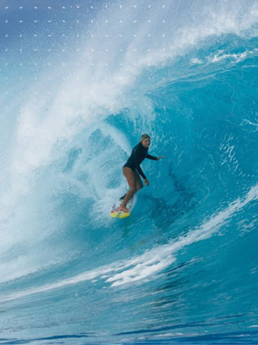 Person surfing a large wave in the ocean