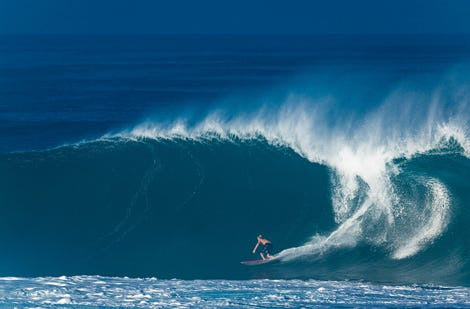 Huge wave with a surfer inside the barrel