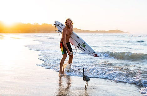 Owen Wright with a bird on beach