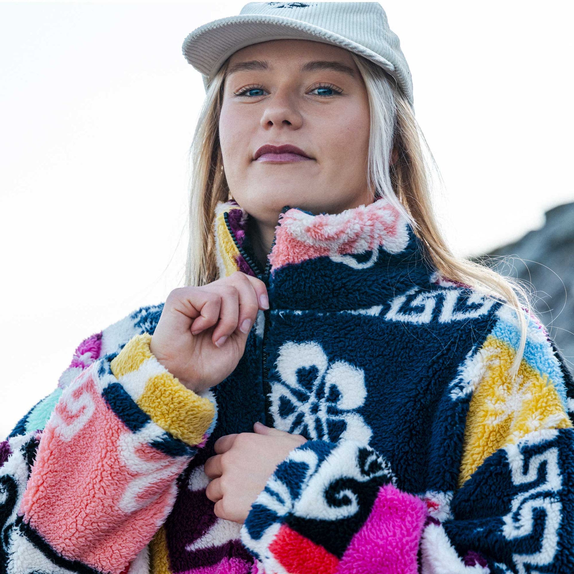 Person wearing a colorful patterned jacket with a blurred background