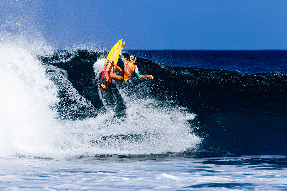 A woman surfer doing a move on surf
