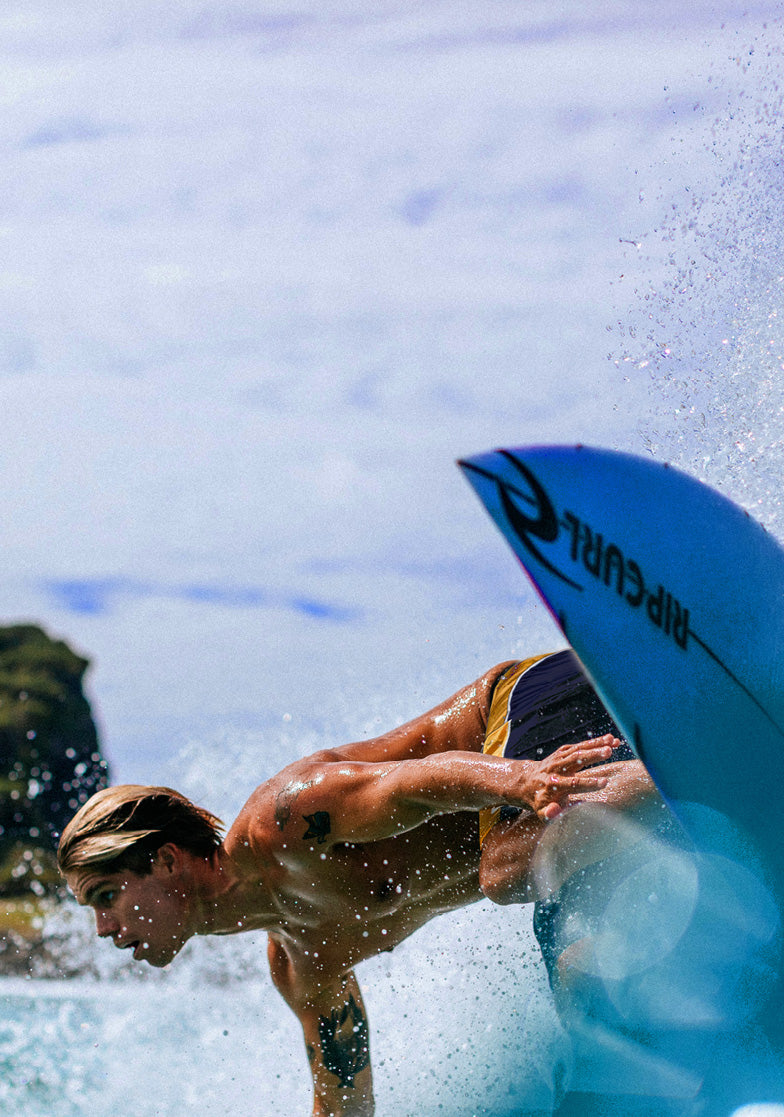Person surfing with a blue surfboard in the water
